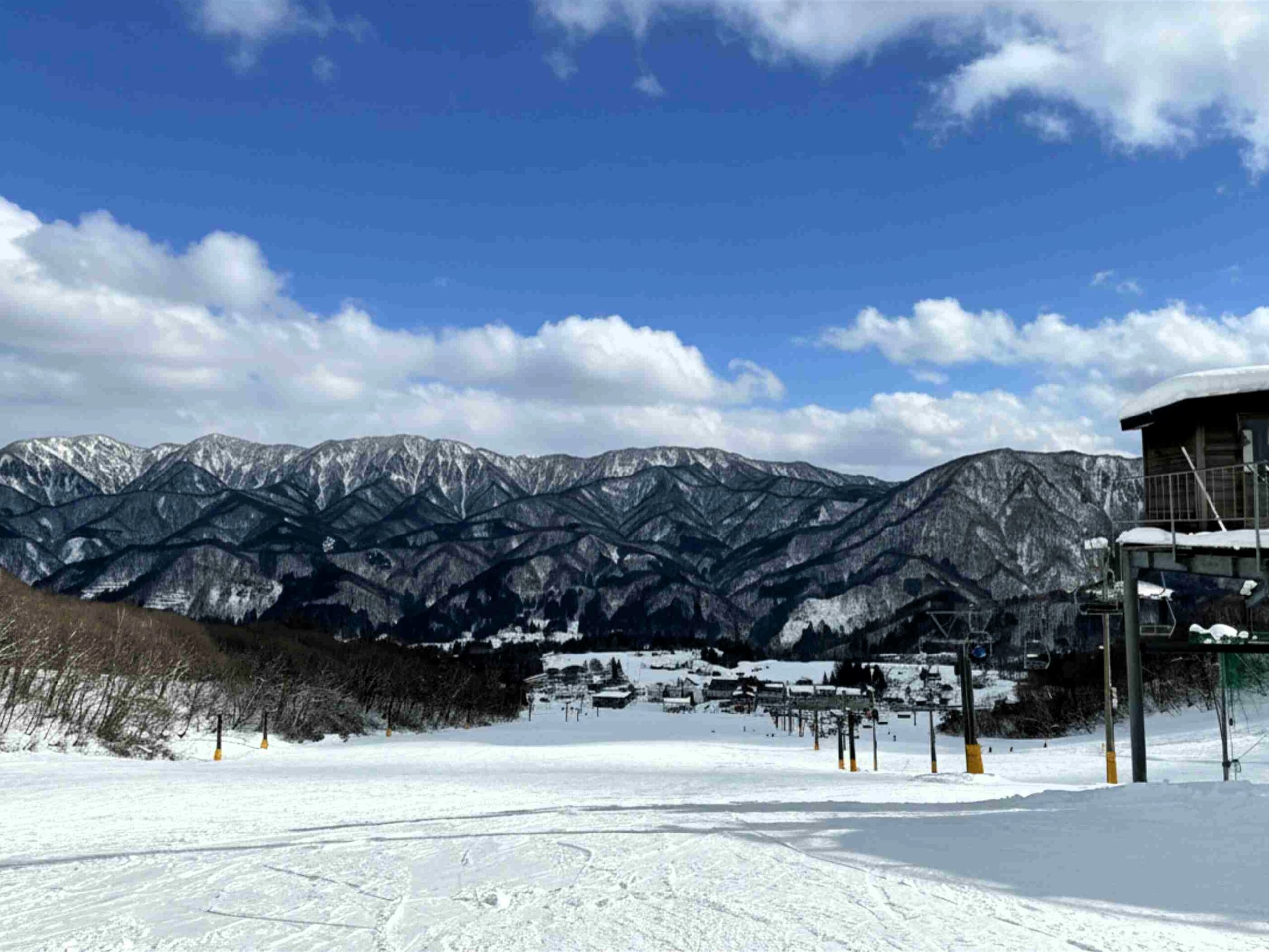 白馬乘鞍滑雪場藍天雪景與寬廣雪道 日本白馬乘鞍滑雪場的積雪雪道,遠眺壯麗的北阿爾卑斯山脈與藍天白雲
